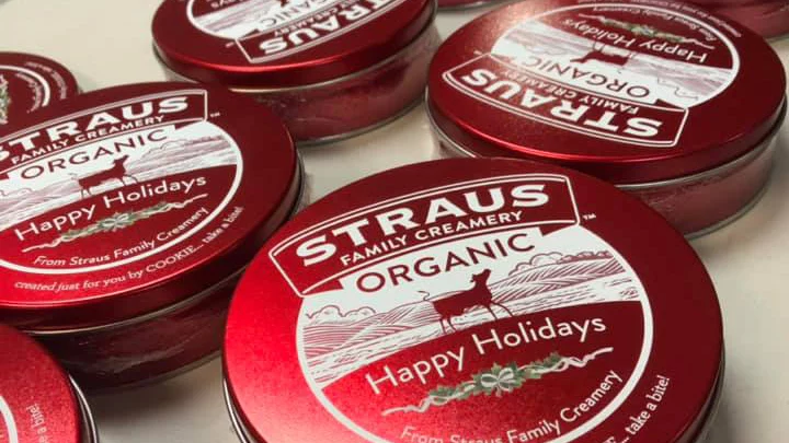 red circular cookie tins with straus family creamery logo and holiday message printed on lid