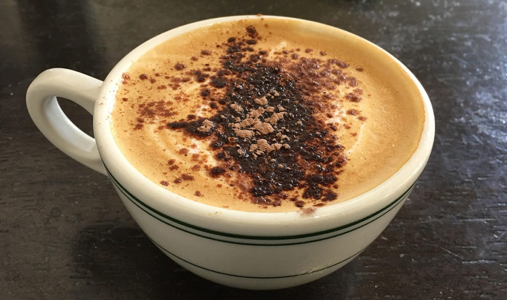 coffee shop mug of pumpkin spice latte with sprinkles