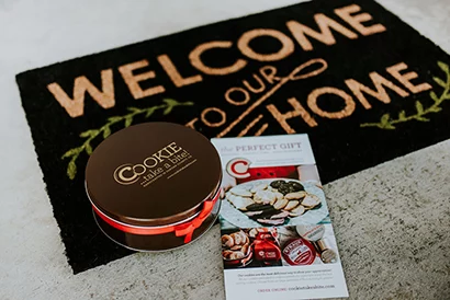 COOKIE...take a bite! gift tin on welcome mat with colorful brochure