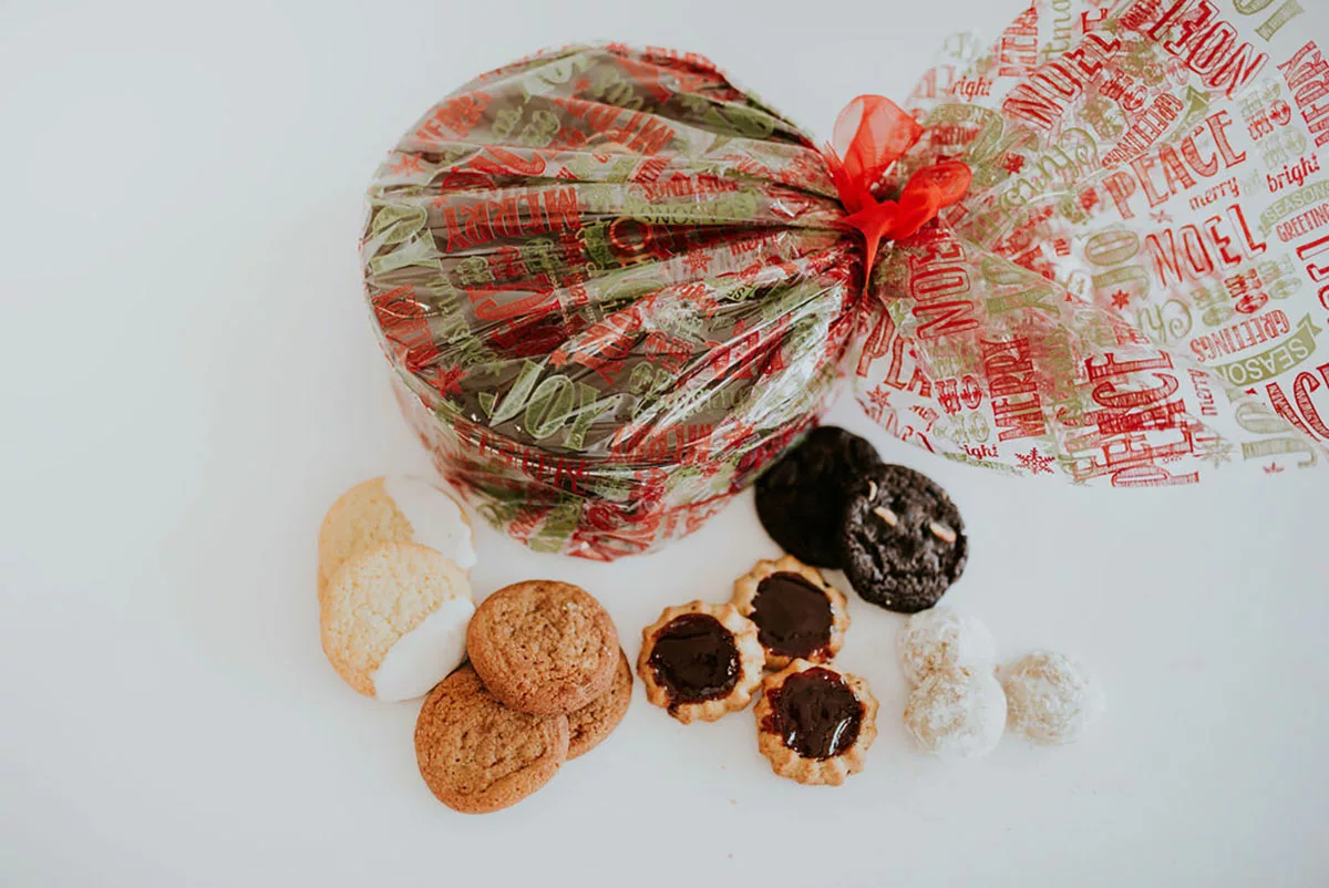 Cookie tin in holiday wrap and an assortment of cookies