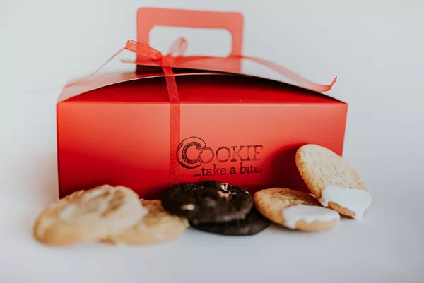 Cookie of the Month cookie subscription box with freshly baked gourmet cookies surrounding it