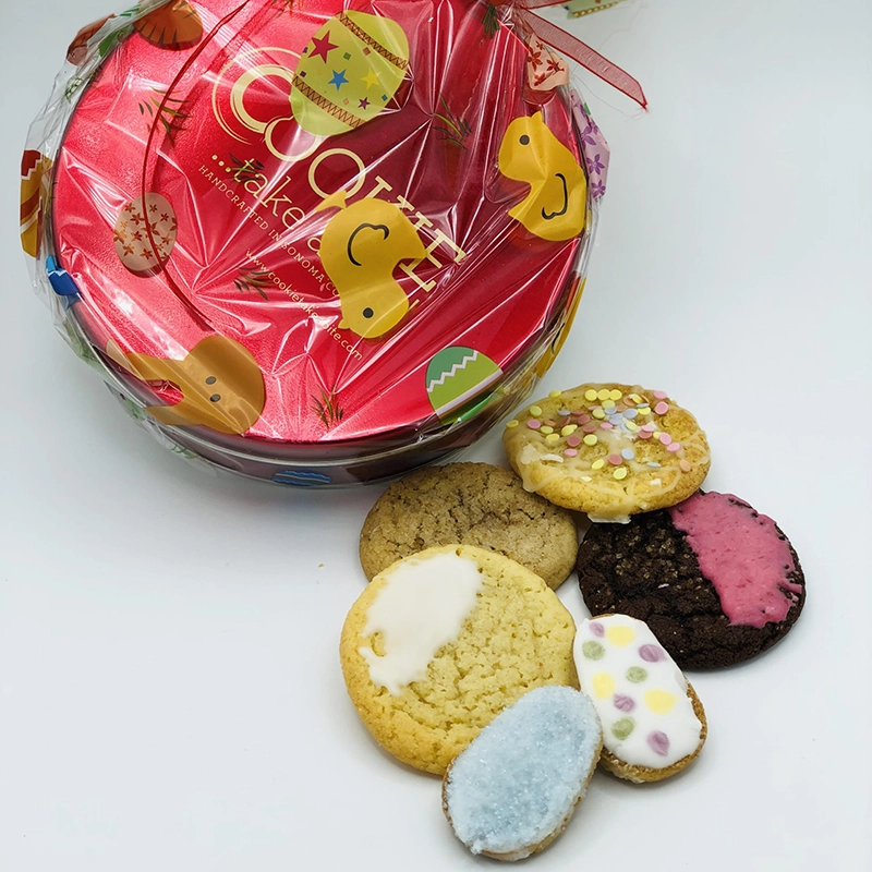 Easter themed cookies with a festively wrapped cookie tin behind them