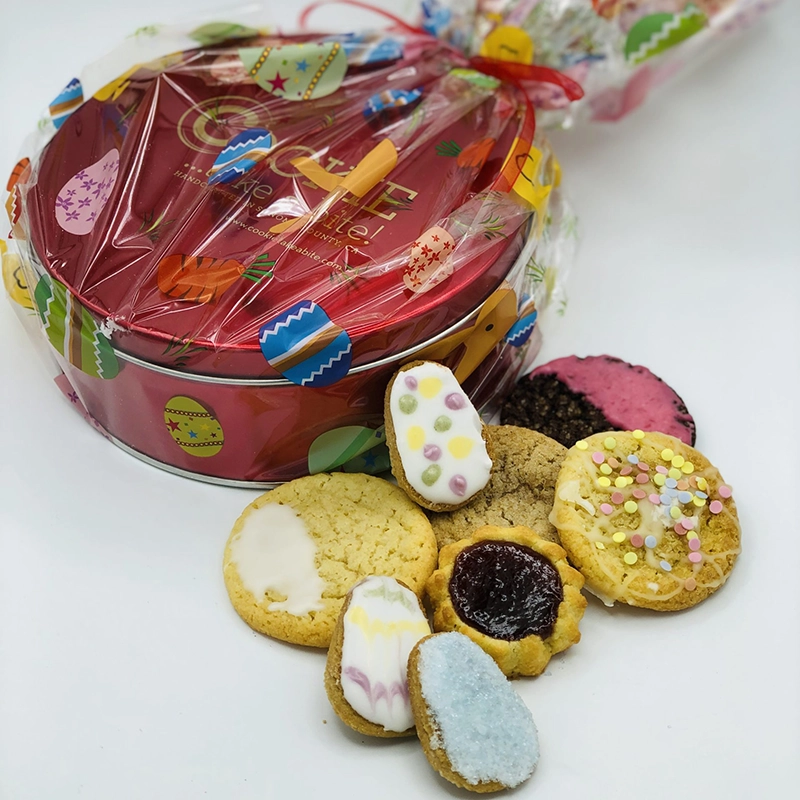 Easter themed cookies with a festively wrapped cookie tin behind them