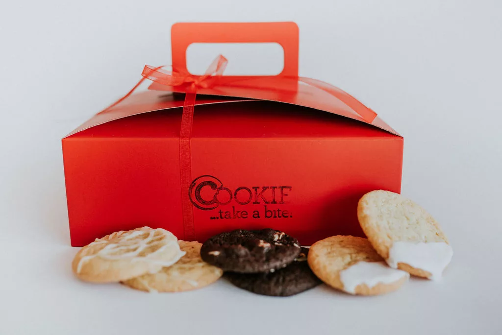 Cookie of the Month cookie subscription box with freshly baked cookies in front of it